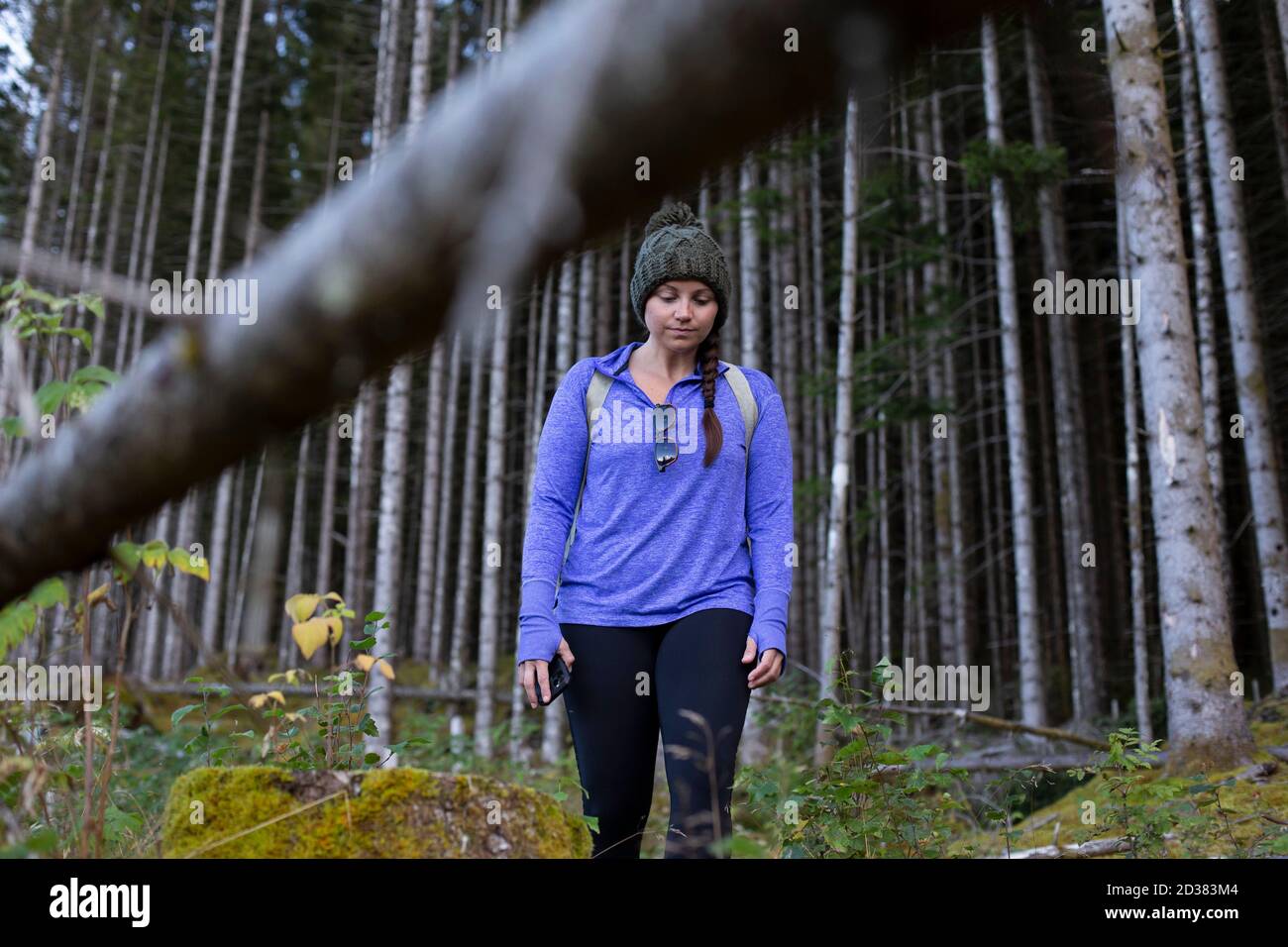 Eine Frau, die aus dem dichten Wald herauskommt Stockfoto