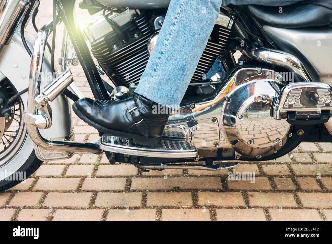 Ein Biker linken Fuß Wechselschaltung Gang auf Custom Chopper Motorrad Stockfoto