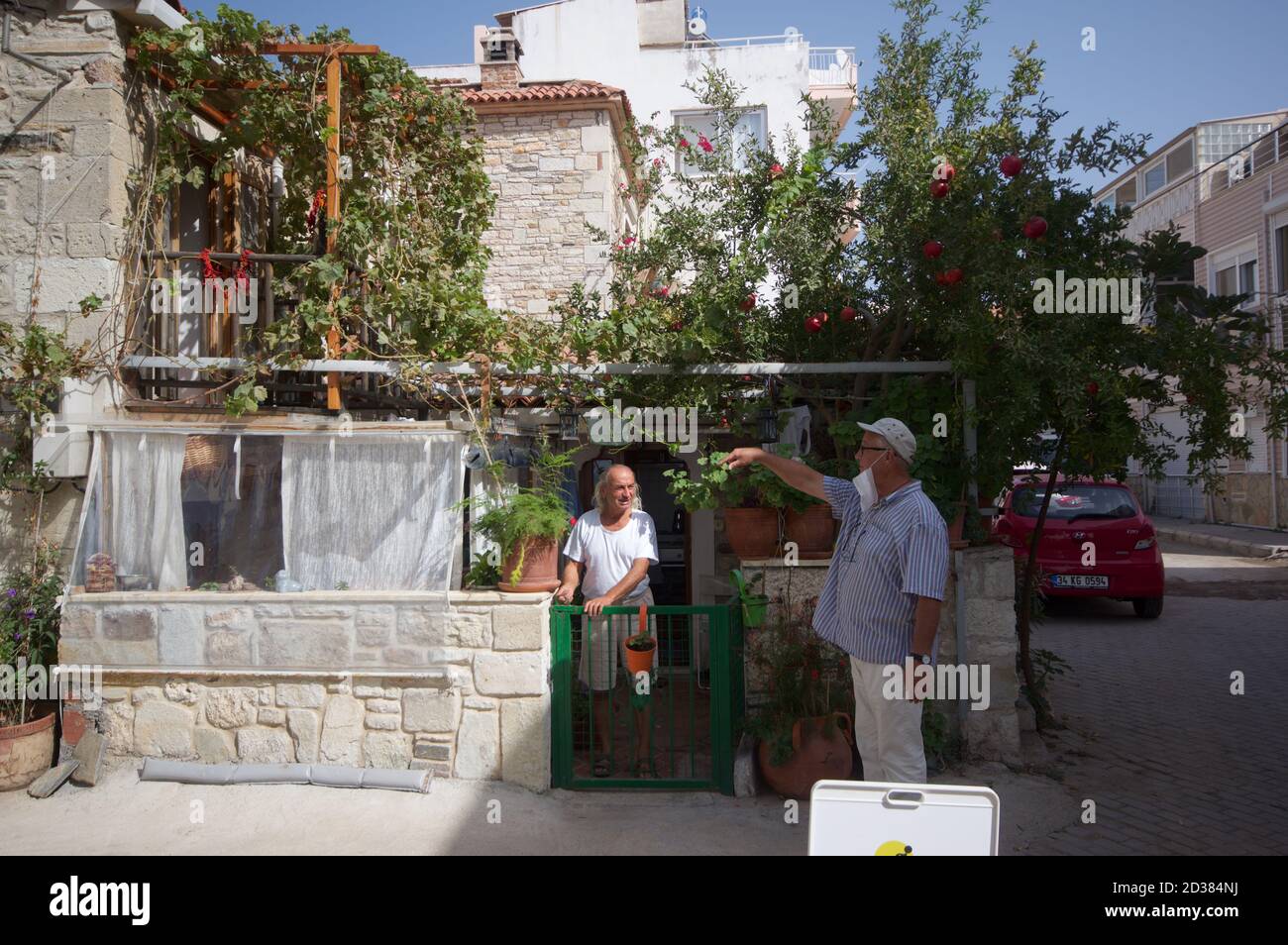 Nachbarn unterhalten sich vor einem Haus in Foca, Türkei Stockfoto