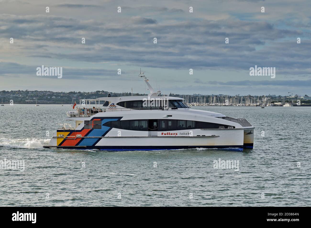 AUCKLAND, NEUSEELAND - 13. März 2019: Auckland / Neuseeland - 13 2019. März: Fullers Fähre fährt schnell Wasser Spray im Waitemata Hafen Stockfoto