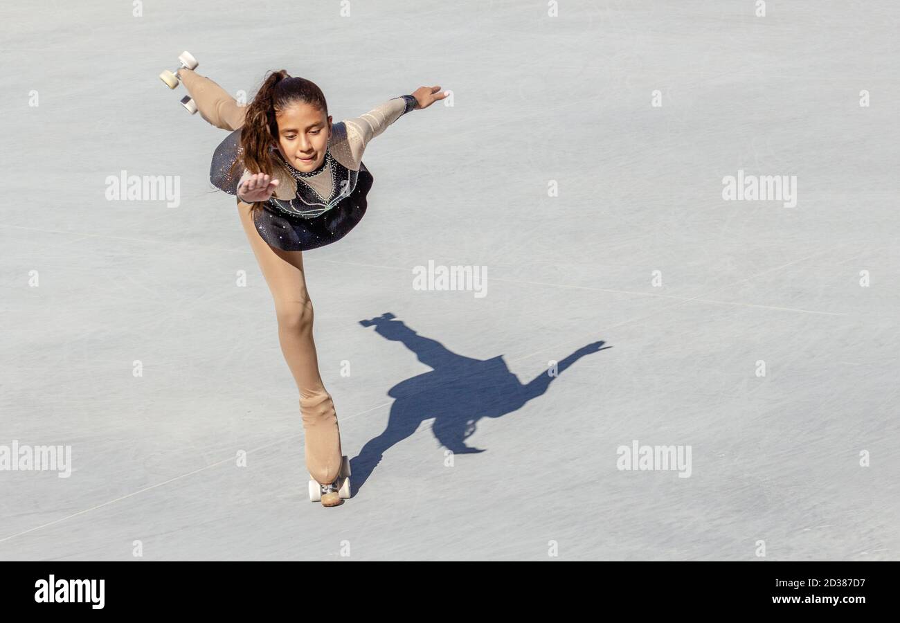 Braunhäutig Teenager-Mädchen Durchführung einer Eiskunstlauf auf Rädern. Taubenfigur Stockfoto