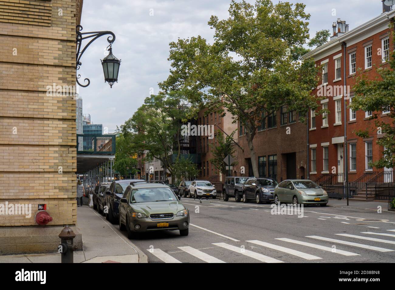 New York City, NY / USA - 7. Oktober 2020: Von Bäumen gesäumte Straße mit historischen Sandsteinhäusern im West Village Viertel in Manhattan, New Stockfoto