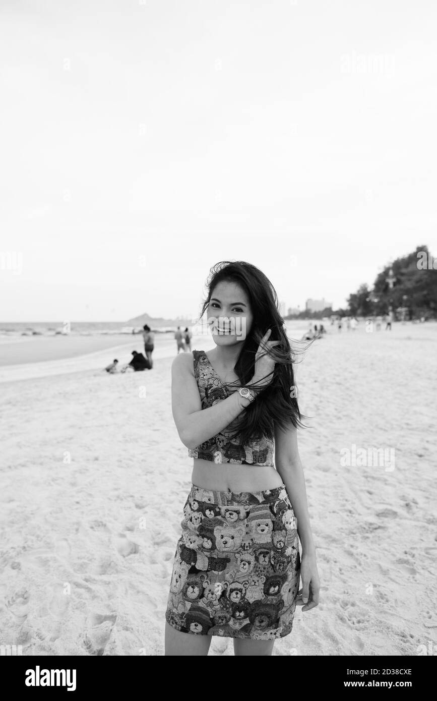 Junge glücklich schöne asiatische Frau lächelnd und stand am Ufer des öffentlichen Strand in Hua Hin Thailand Stockfoto