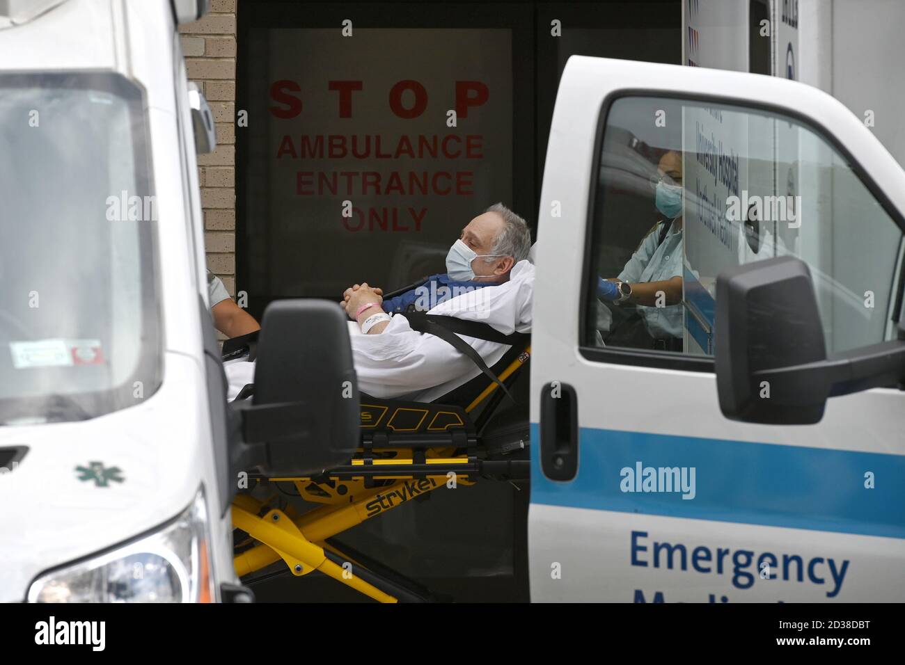 Ein Patient wird am 7. Oktober 2020 in einen wartenden Krankenwagen im Long Island Jewish Forest Hills Hospital in der ausgewiesenen „roten Zone“ des Rego Park-Viertels in Queens, NY, transportiert. Gov. Andrew Cuomo hat ein dreistufiges Farbzonensystem (gelb, orange und rot) eingeführt, anstatt Postleitzahlen zu verwenden, um die Viertel zu identifizieren, die eine signifikante Spitze bei Coronavirus-Infektionen sehen, und verschiedene Einschränkungen auf der Grundlage der Farbe der Zone, rot ist die höchste. Die Beschränkungen der roten Zone umfassen maximal 10 Personen in Gotteshäusern, Gruppenversammlungen sind nur verboten Stockfoto