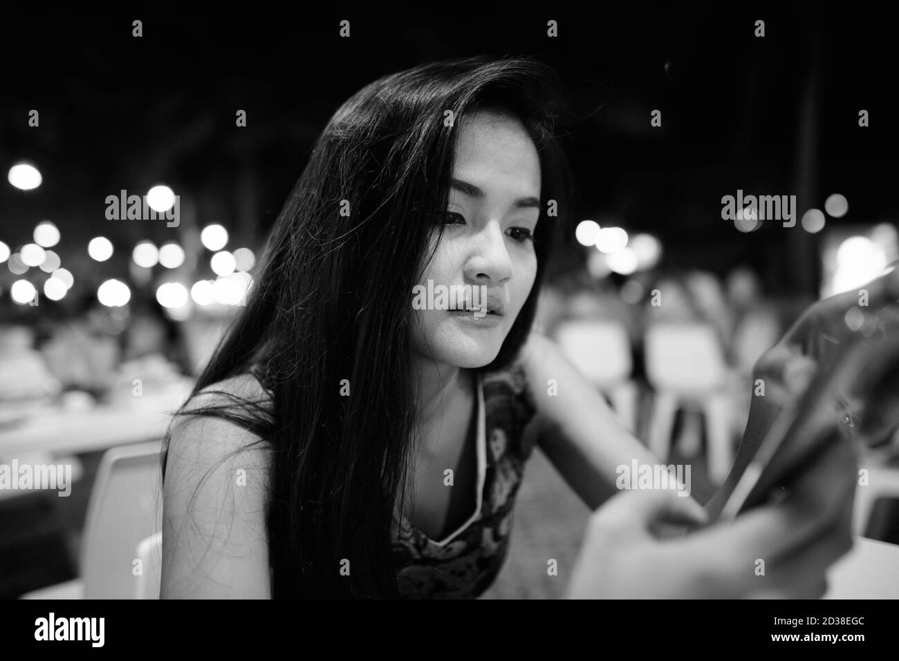 In der Nähe der Jugendlichen schöne asiatische Frau mit ihrem Mobiltelefon auf dem Nachtmarkt von Hua Hin in Thailand Stockfoto