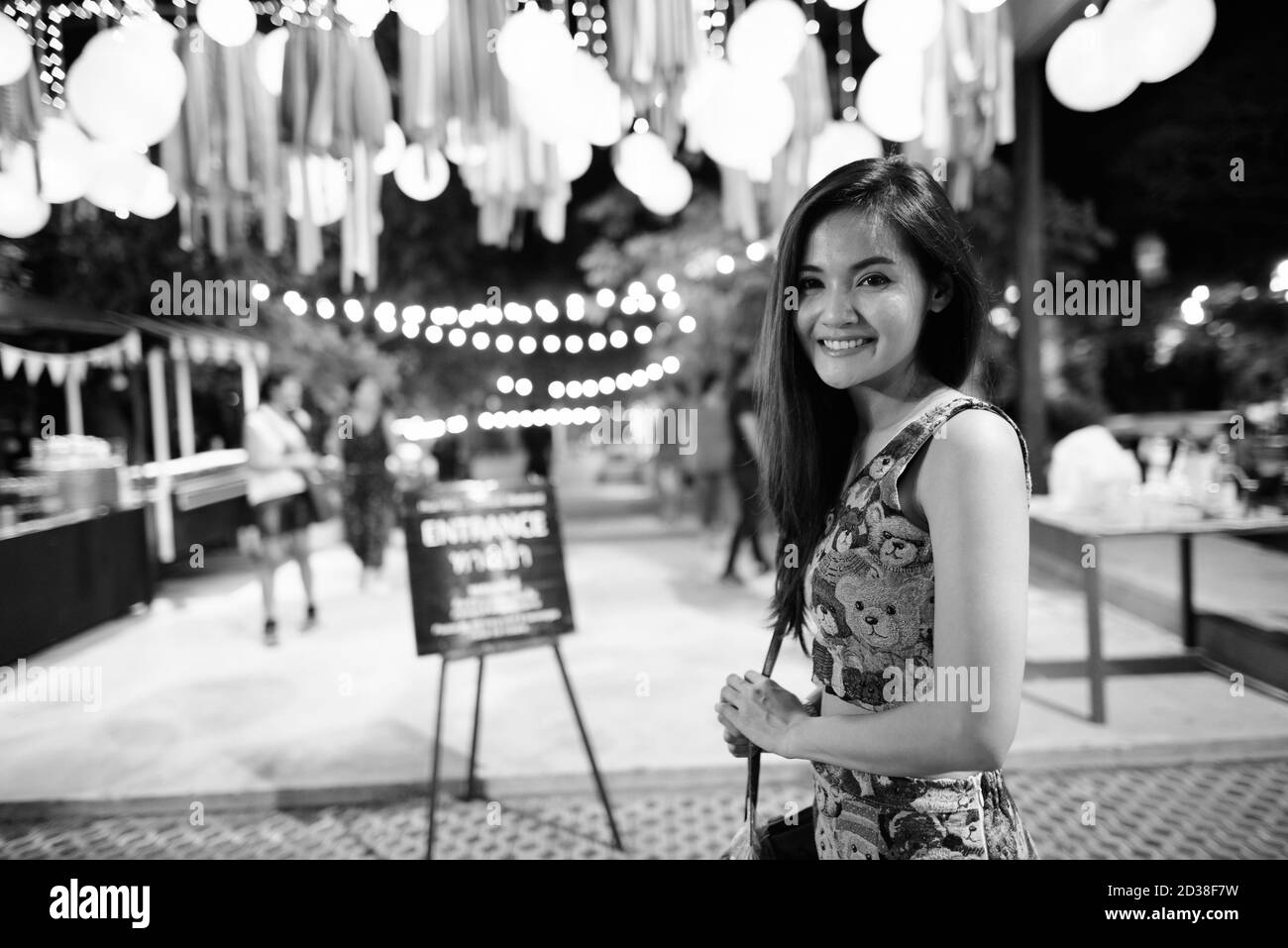 Junge glücklich schöne asiatische Frau am Eingang des offenen Live Band in der Nachtmarkt von Hua Hin Thailand lächelnd Stockfoto