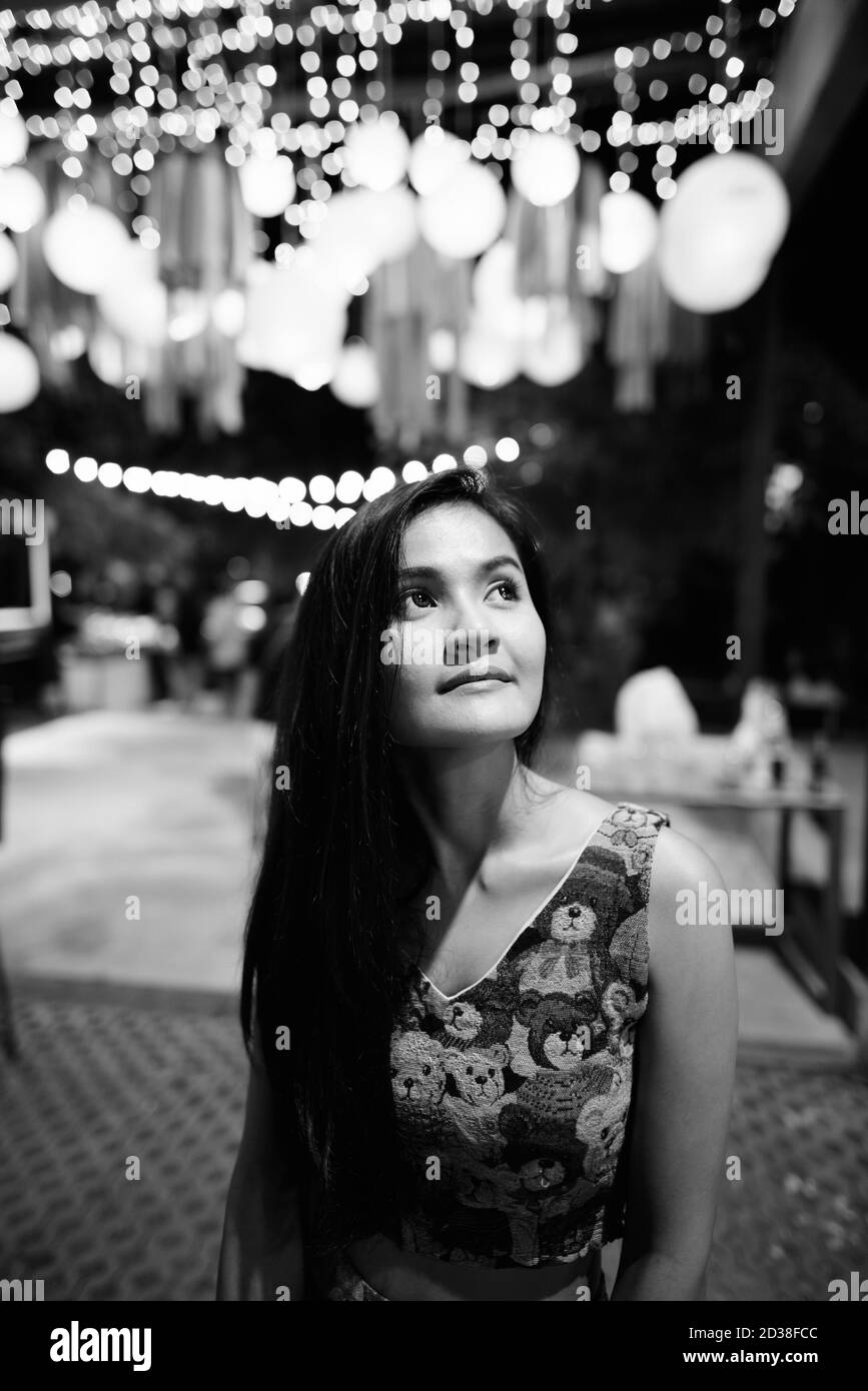 Junge schöne asiatische Frau, die gegen szenische Sicht des Lichts denkt Laternen auf dem Nachtmarkt Stockfoto