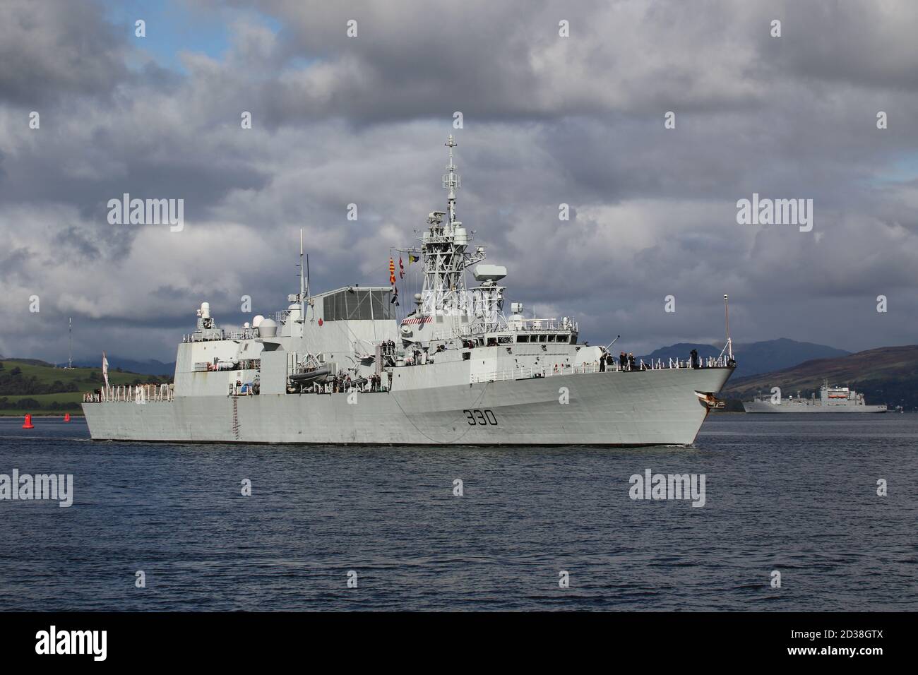 HMCS Halifax (FFH-330), eine von der Royal Canadian Navy betriebene Fregatte der Halifax-Klasse (oder City-Klasse), passiert Greenock bei ihrer Ankunft für die Übung Joint Warrior, mit einer früheren Ankunft in Form des US Navy-Hilfsschiffs USNS Medgar Evers im Hintergrund. Stockfoto