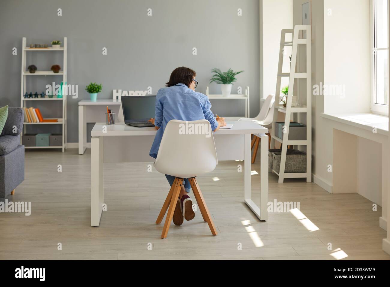 Hart arbeitende Geschäftsfrau, die im Notebook schreibt und Computer benutzt Am Schreibtisch im Heimbüro Stockfoto