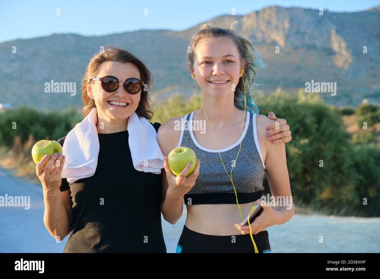 Sportlich gesunde Familienleben, glückliche Mutter und Tochter im Teenageralter essen Äpfel Stockfoto