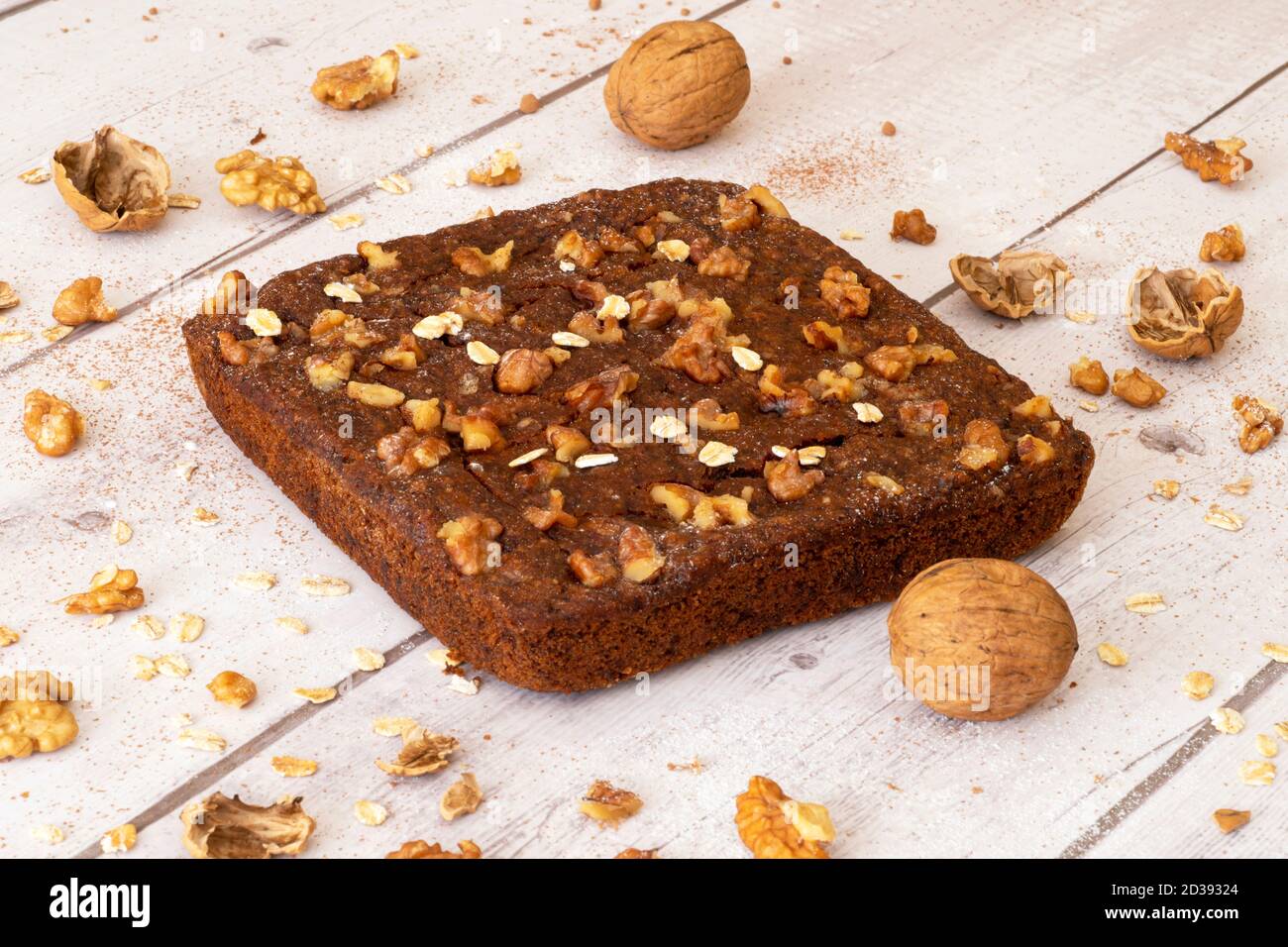 Gebackene Walnuss und Hafer Schokoladenkuchen garniert mit Nüssen und Hafer auf einem hellen Hintergrund Stockfoto