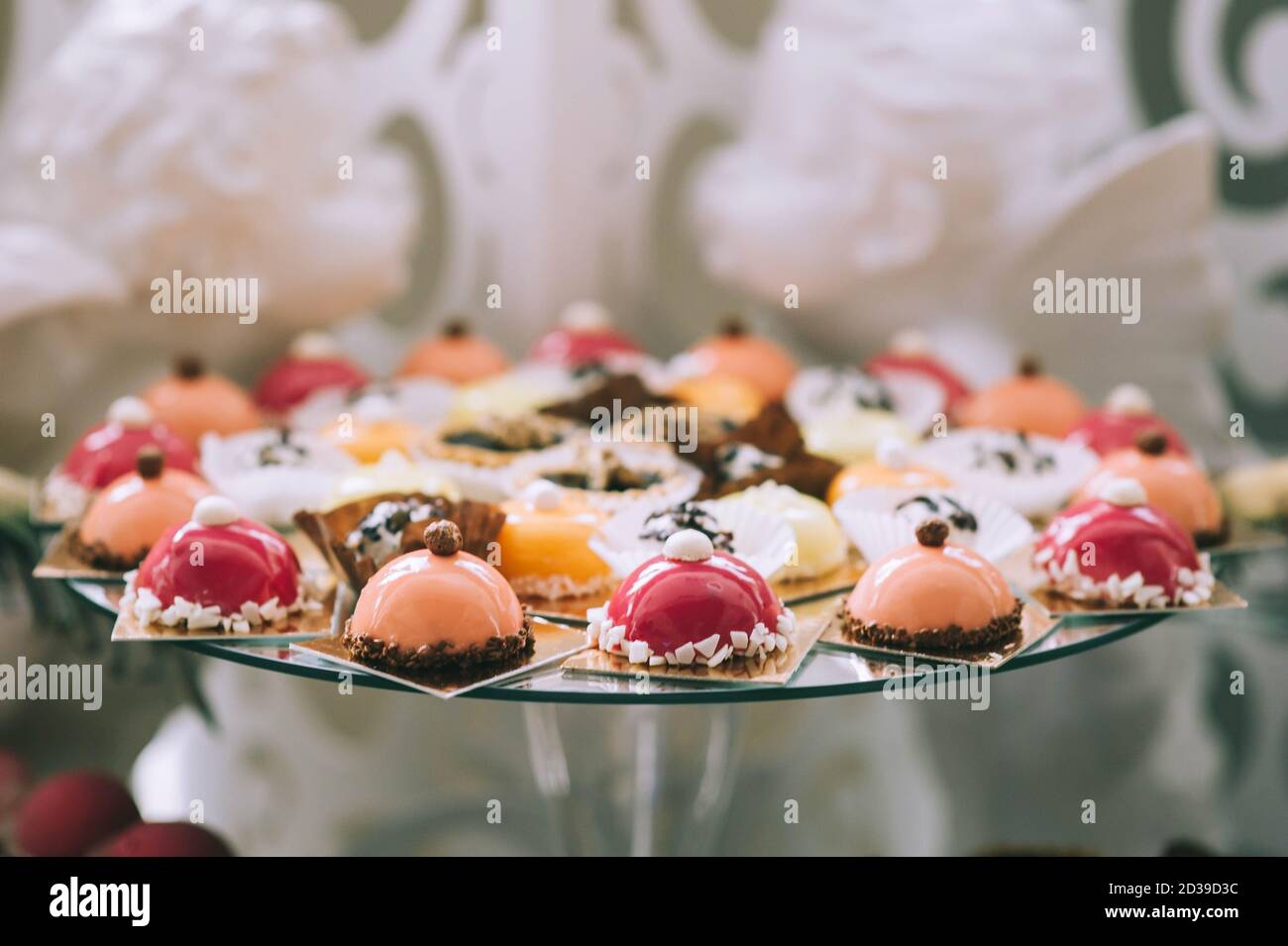 Verschiedene farbige leckere Süßigkeiten auf dem Tisch in einer Süßigkeitenbar bei einer Hochzeit. Köstliche Süßigkeiten auf Hochzeit Süßigkeiten Buffet mit Desserts, Cupcakes. Sweet Tab Stockfoto