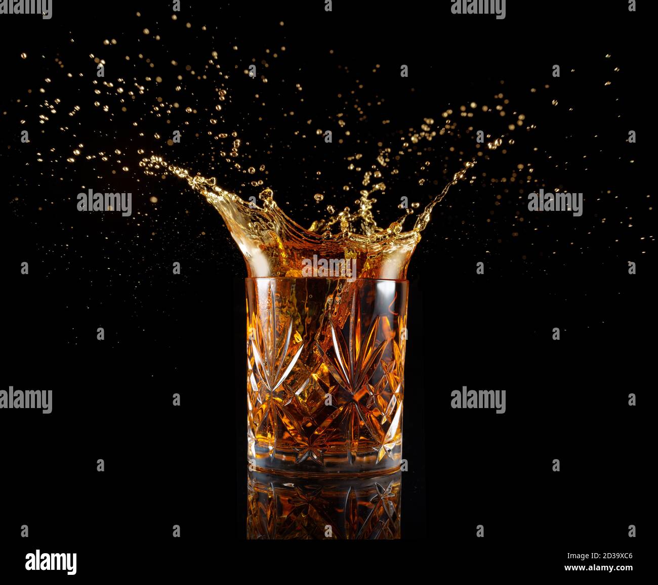Schnapsglas spritzt isoliert auf schwarz Stockfoto