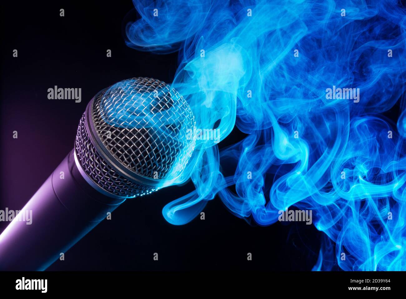 Mikrofon und blauer Rauch wirbeln auf schwarzem Hintergrund Stockfoto
