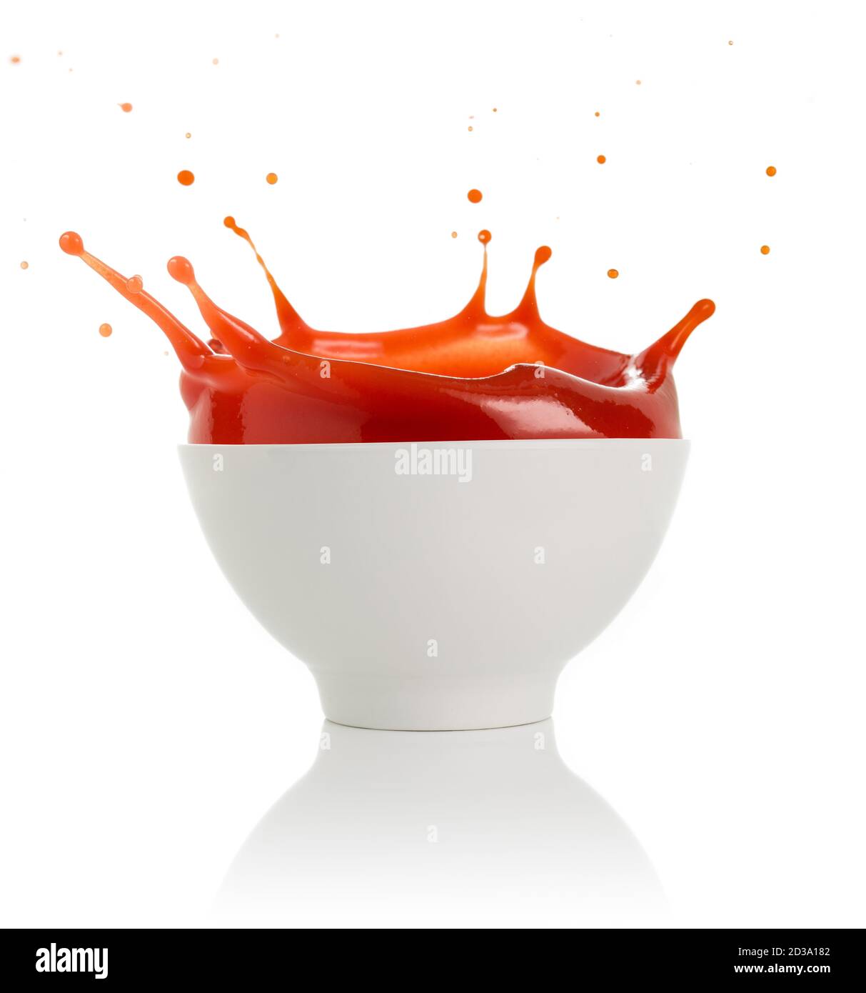Tomatensuppe spritzt aus einer Schüssel isoliert auf weiß Stockfoto