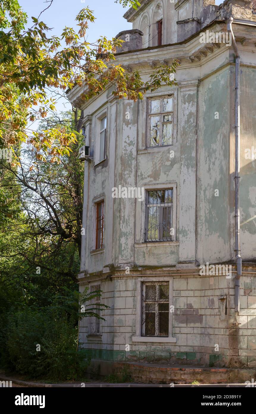 Verfallene Fassade eines alten Gebäudes in einem Herbstpark. Dreistöckiges Gebäude aus dem 19. Jahrhundert, renovierungsbedürftig. Historische Architektur Stockfoto