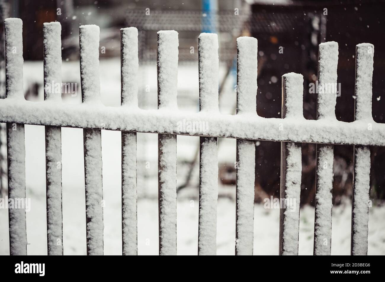 Alte Holzzaun mit Schnee bedeckt. Das kaputte Teil. Stockfoto