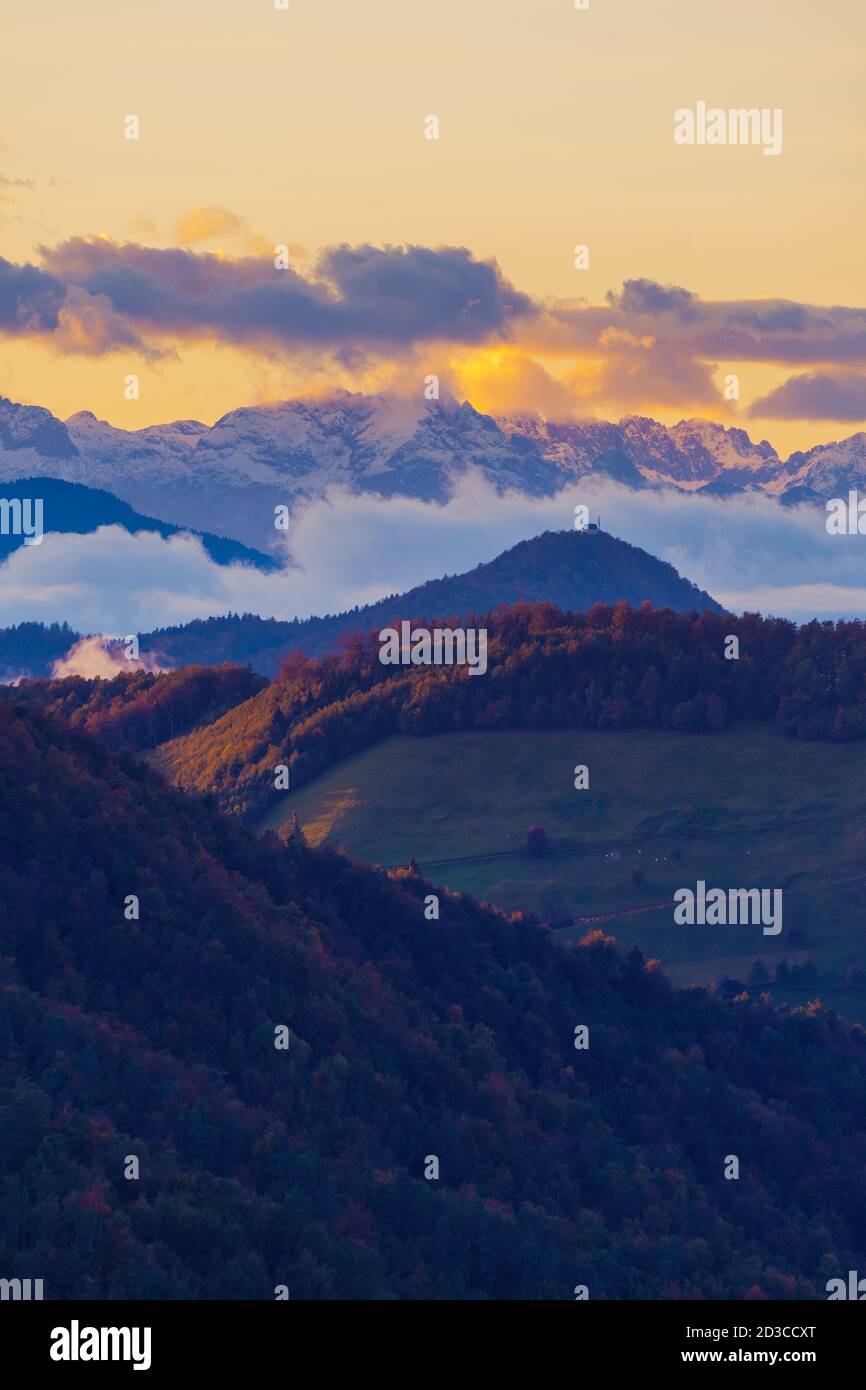 Herrliche Aussicht auf Hügel und Alpengipfel bei Sonnenuntergang in Slowenien. Wandern, Natur, Umwelt und Wetterkonzepte Stockfoto