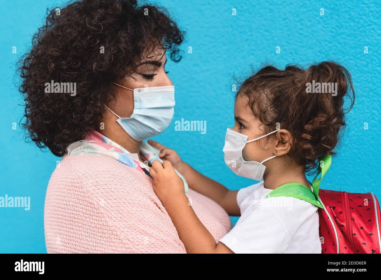 Mutter und Tochter tragen Gesichtsschutzmaske zurück zu gehen Schule während der Corona-Virus-Pandemie - Gesundheits- und Bildungskonzept Stockfoto