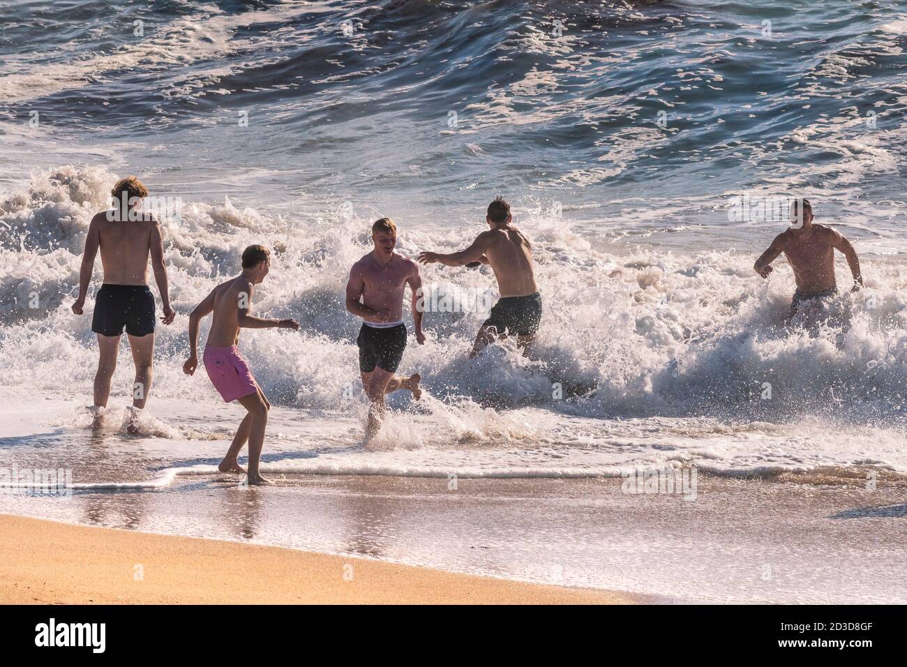 Männliche Urlauber verbringen ihren Urlaub im Meer am Fistral Beach in Newquay in Cornwall. Stockfoto