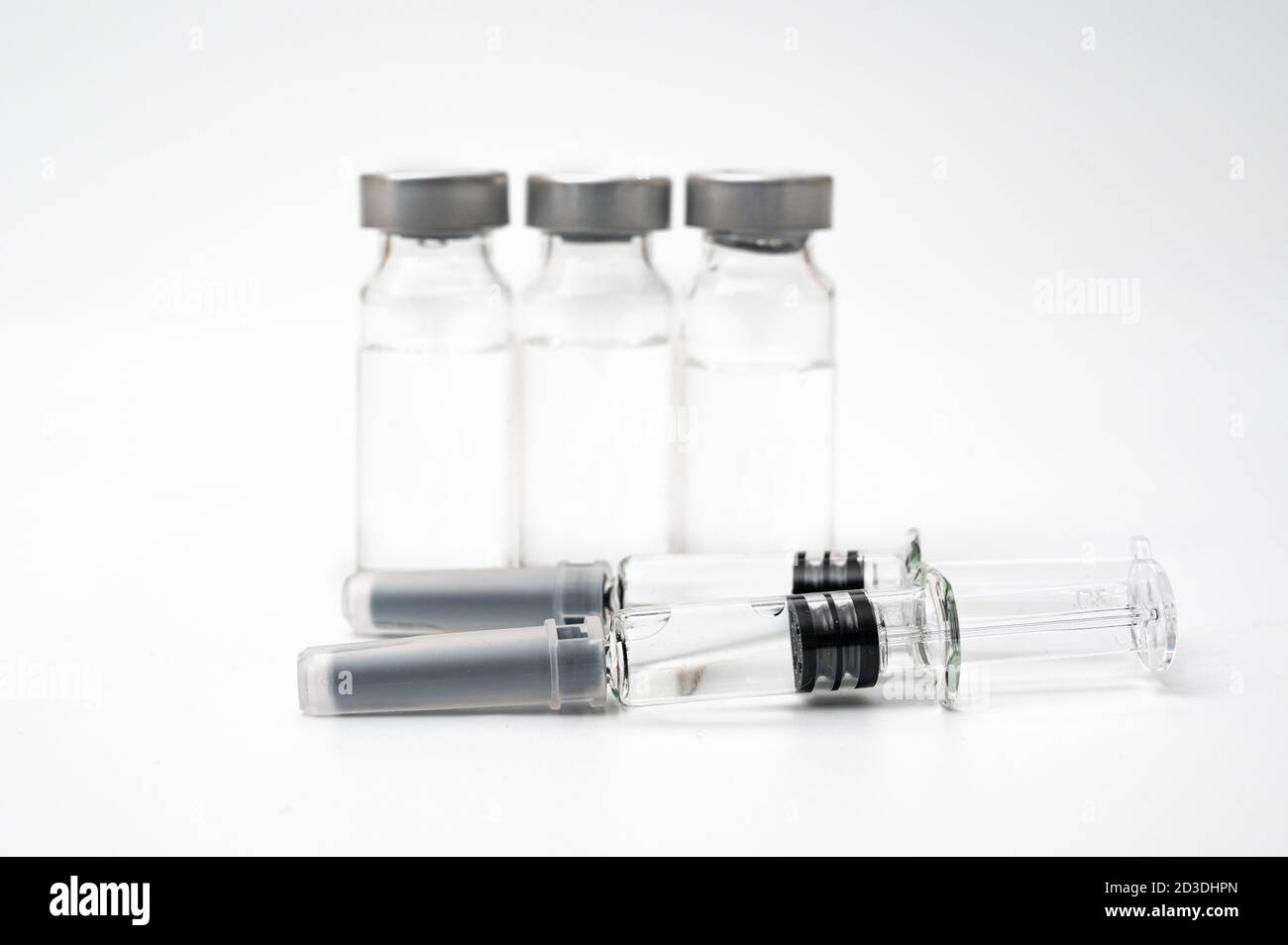 Impfkonzept mit Spritze und Fläschchen auf weißem Hintergrund. Stockfoto