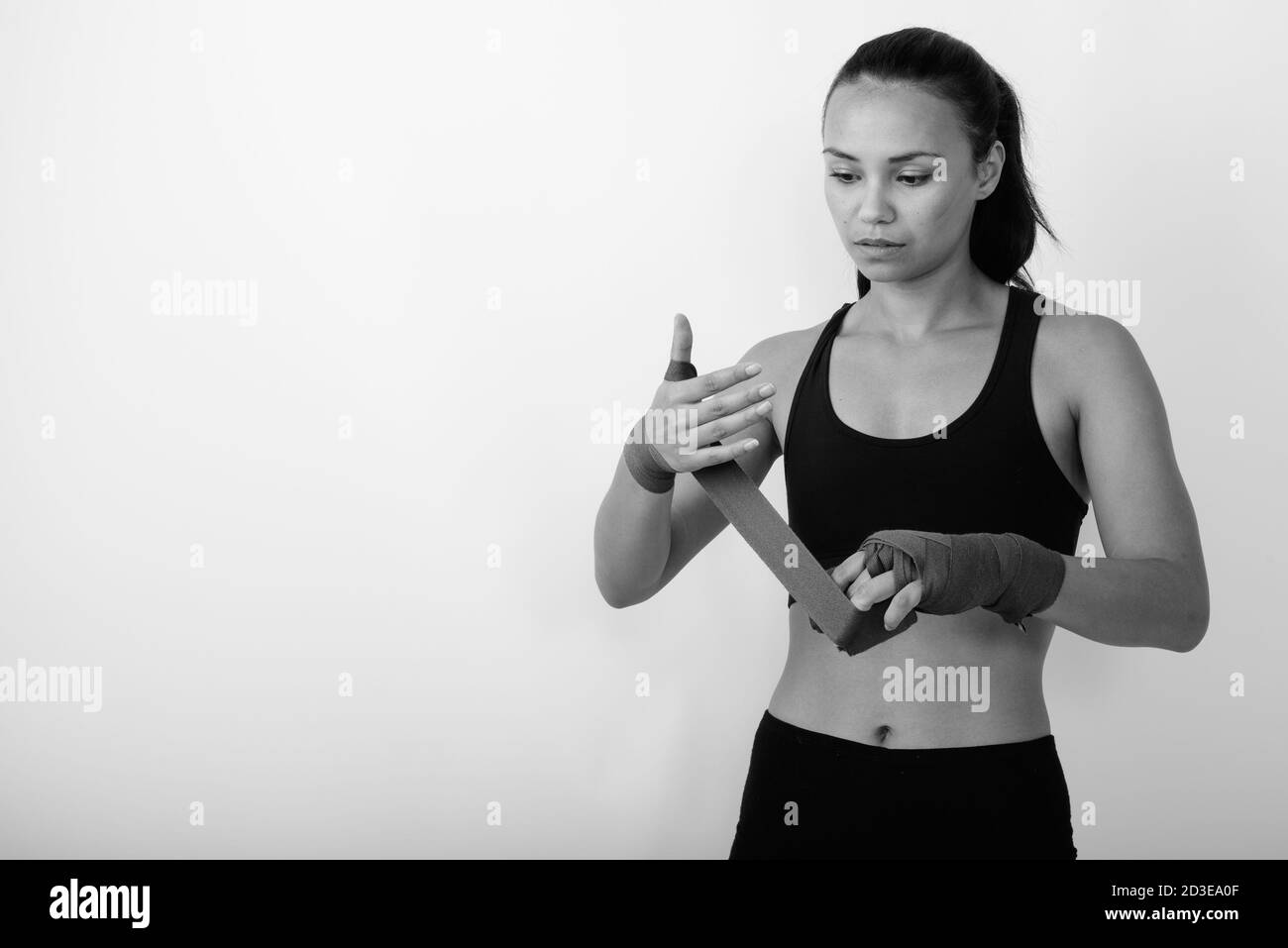 Studio Schuss der jungen asiatischen Frau Kämpfer wickeln ihre Hand Mit Boxpackungen vor weißem Hintergrund Stockfoto
