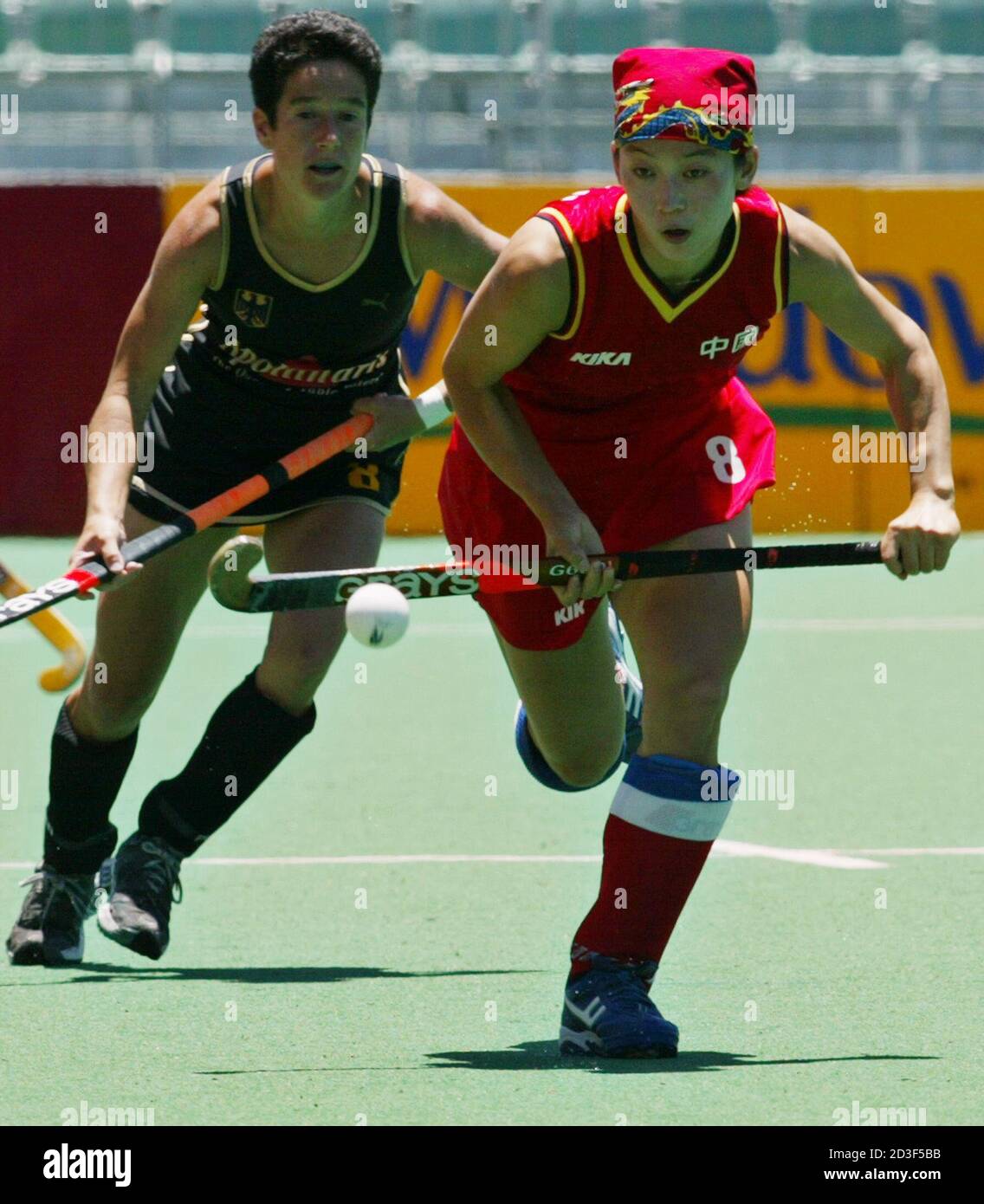 Chinas Baorong Fu nimmt den Ball am 3. Dezember 2002 im Perth Hockey Stadium in Westaustralien an der deutschen Melanie Cremer vorbei. China besiegte Deutschland 3:1. REUTERS/Mark Baker MDB/PB Stockfoto