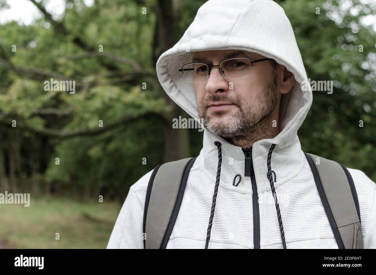 Porträt eines Mannes mittleren Alters in einem Kapuzenpullover In einem Park Stockfoto