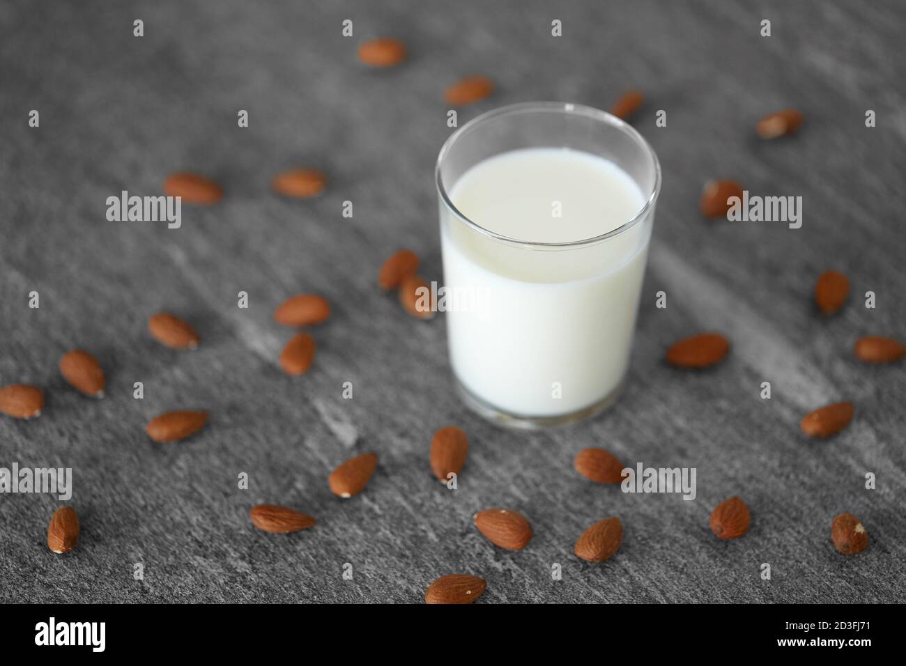 Glas laktosefreie Milch und Mandeln auf dem Tisch Stockfoto