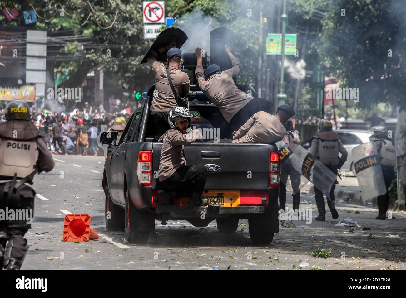 Medan, Nord-Sumatra, Indonesien. Okt. 2020. Die Bereitschaftspolizei zerstreut Demonstranten, die am 8. Oktober 2020 bei einer Demonstration in Medan, Nord-Sumatra, Steine werfen. Tausende von wütenden Studenten und Arbeitern führen am Donnerstag Kundgebungen in ganz Indonesien gegen ihr neues Gesetz durch. Sie sagten, dass dies die Arbeitsrechte lähmen und der Umwelt schaden würde. Quelle: Albert Ivan Damanik/ZUMA Wire/Alamy Live News Stockfoto