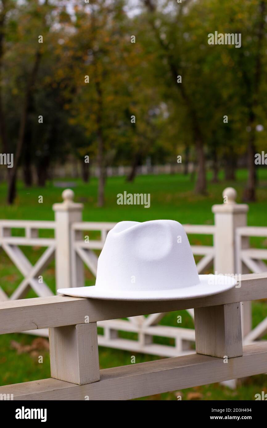 Weiße stilvolle Unisex Hut auf dem Zaun. Stockfoto