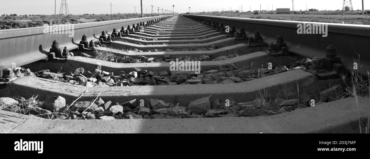 Schienen und Schwellen als Symbol des Eisenbahnverkehrs In schwarz und weiß Stockfoto