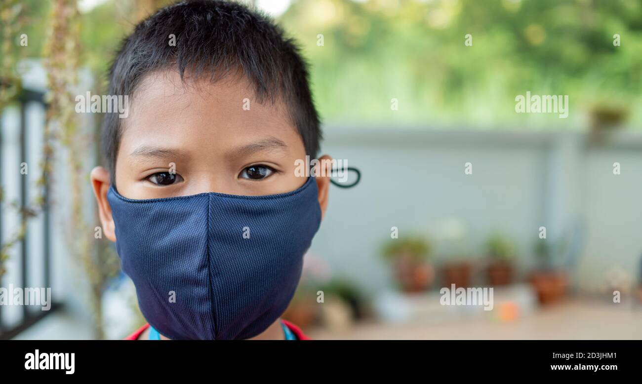 Nahaufnahme Porträt eines niedlichen Jungen trägt eine Schutzmaske und er schaut auf die Kamera. Stockfoto