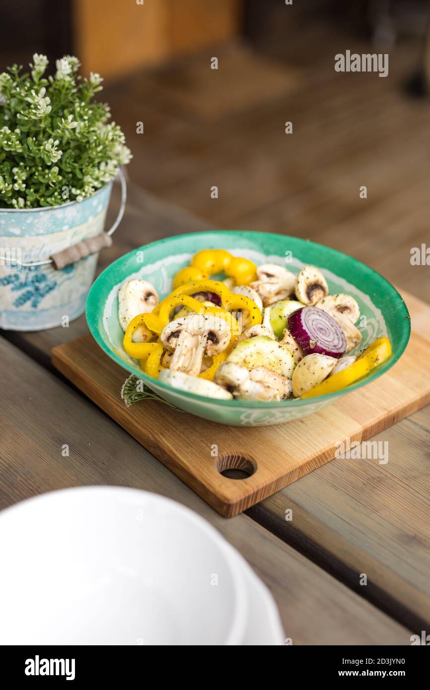 Eine Schüssel mariniertes Gemüse für das Grillen im Freien vorbereitet. Dinnerparty für Freunde. Stockfoto