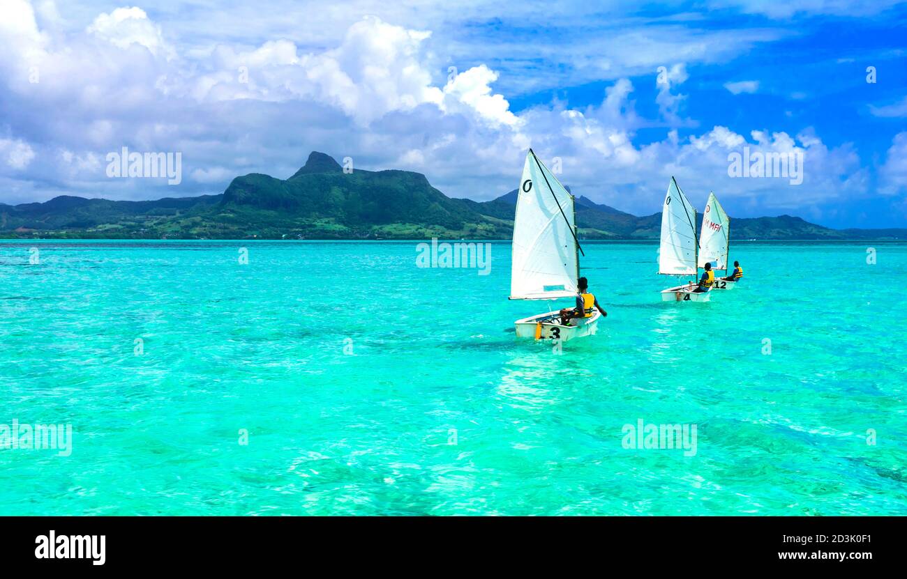 Atemberaubende Blue Bay mit transparentem türkisfarbenem Meer. Jungs in Segelbooten. Mauritius-Insel. Januar 2020 Stockfoto