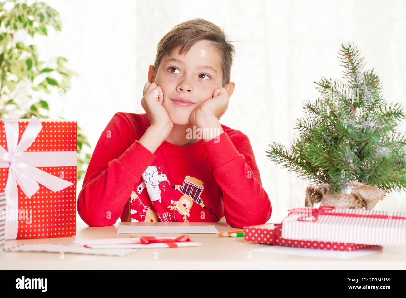 Kleiner Junge schreibt einen Brief an den Weihnachtsmann zu Weihnachten Geschenk und Wünsche Stockfoto