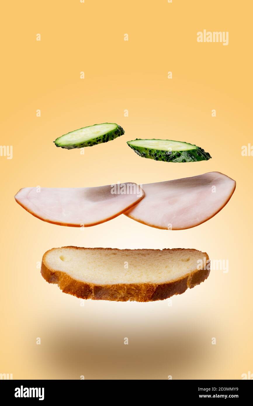 Sandwich-Levitation mit Schinken und Gurken. Das Konzept der Fast Food Stockfoto