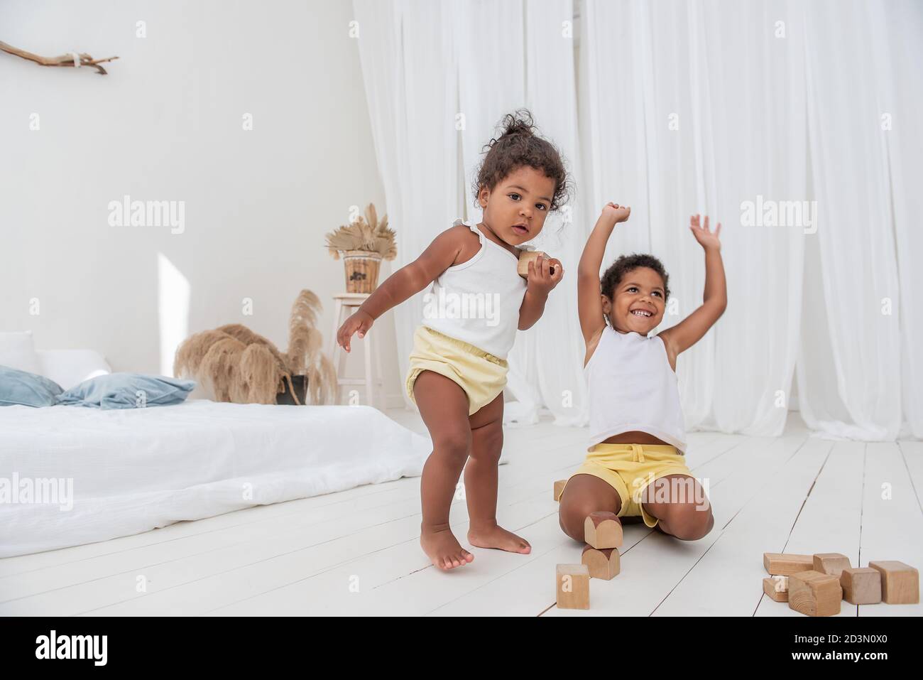 Kleiner Bruder und Schwester African American spielen Häuser mit Holz Öko-Ziegel, bauen und zerstören Türme. Feinmotorik Entwicklung, pädagogische Spiele. Wh Stockfoto