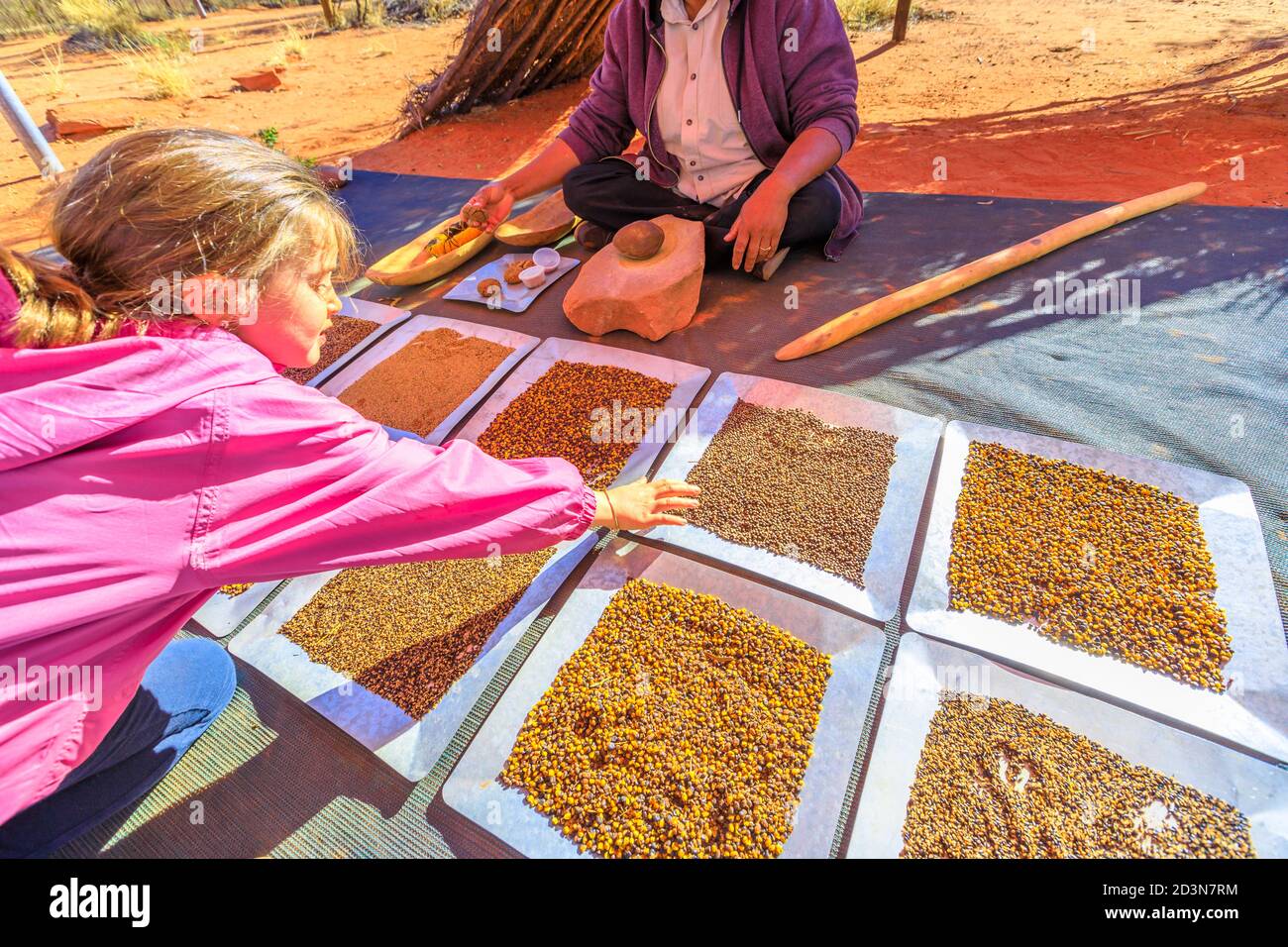 Kings Creek, Australien - 21. Aug 2019: Touristen erleben die Kultur der australischen Aborigines und zeigen die traditionellen Buschsamen, für die sie verwendet werden Stockfoto