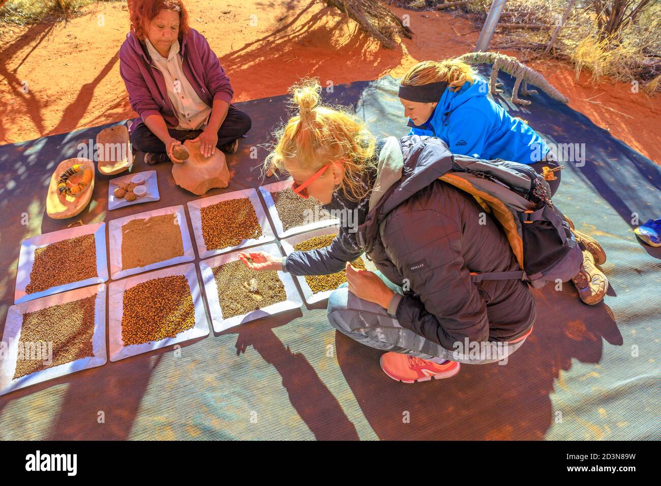 Kings Creek, Australien - 21. Aug 2019: Touristen erleben die Kultur der australischen Aborigines und zeigen die traditionellen Buschsamen, für die sie verwendet werden Stockfoto