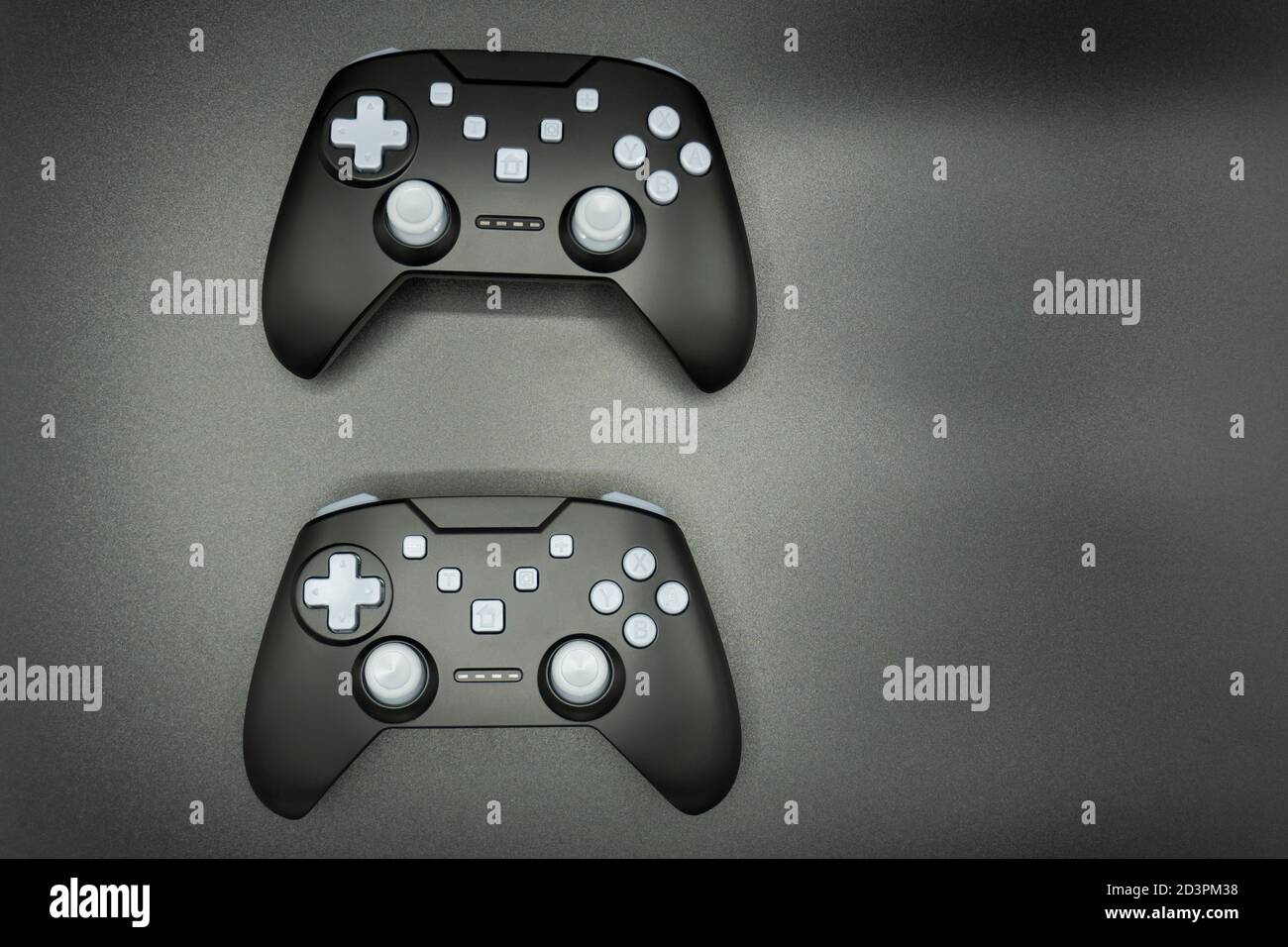 Zwei schwarze Spiel Joysticks mit weißen Tasten isoliert auf grau Hintergrund Stockfoto