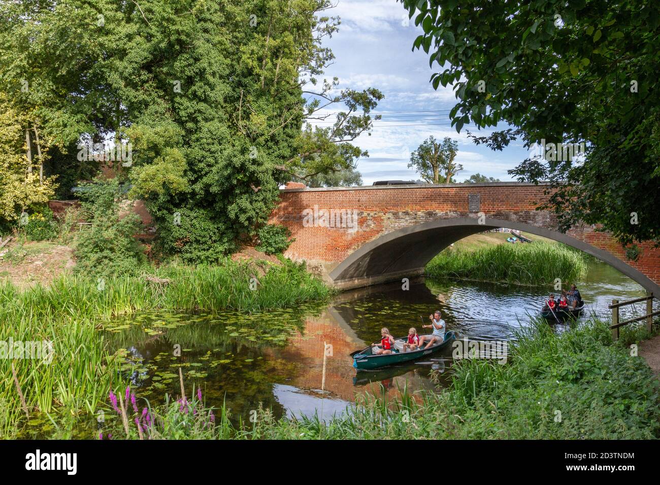 Familiengruppen Kanufahren entlang des Flusses Stour in Nayland, im Stour Valley, Suffolk, Großbritannien. Stockfoto