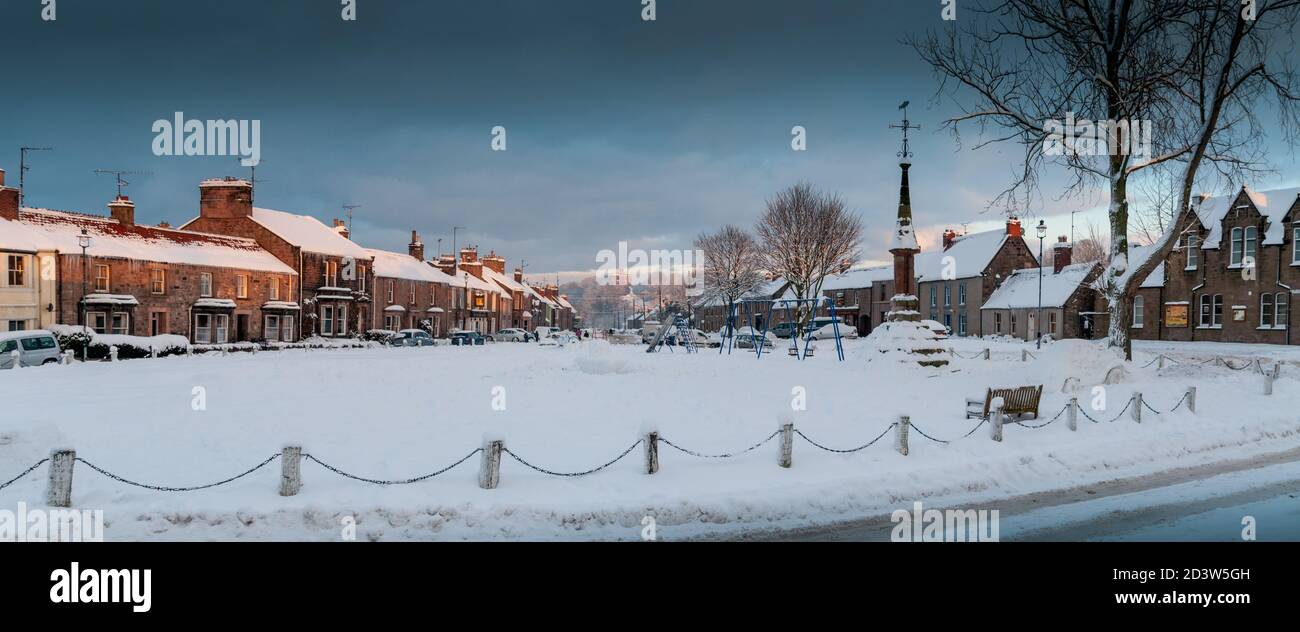 Das Dorf Norham mit seinem Dorf grün und mittelalterlichen Marktkreuz Blick auf die Ruinen des Schlosses, Northumberland, England, Großbritannien Stockfoto