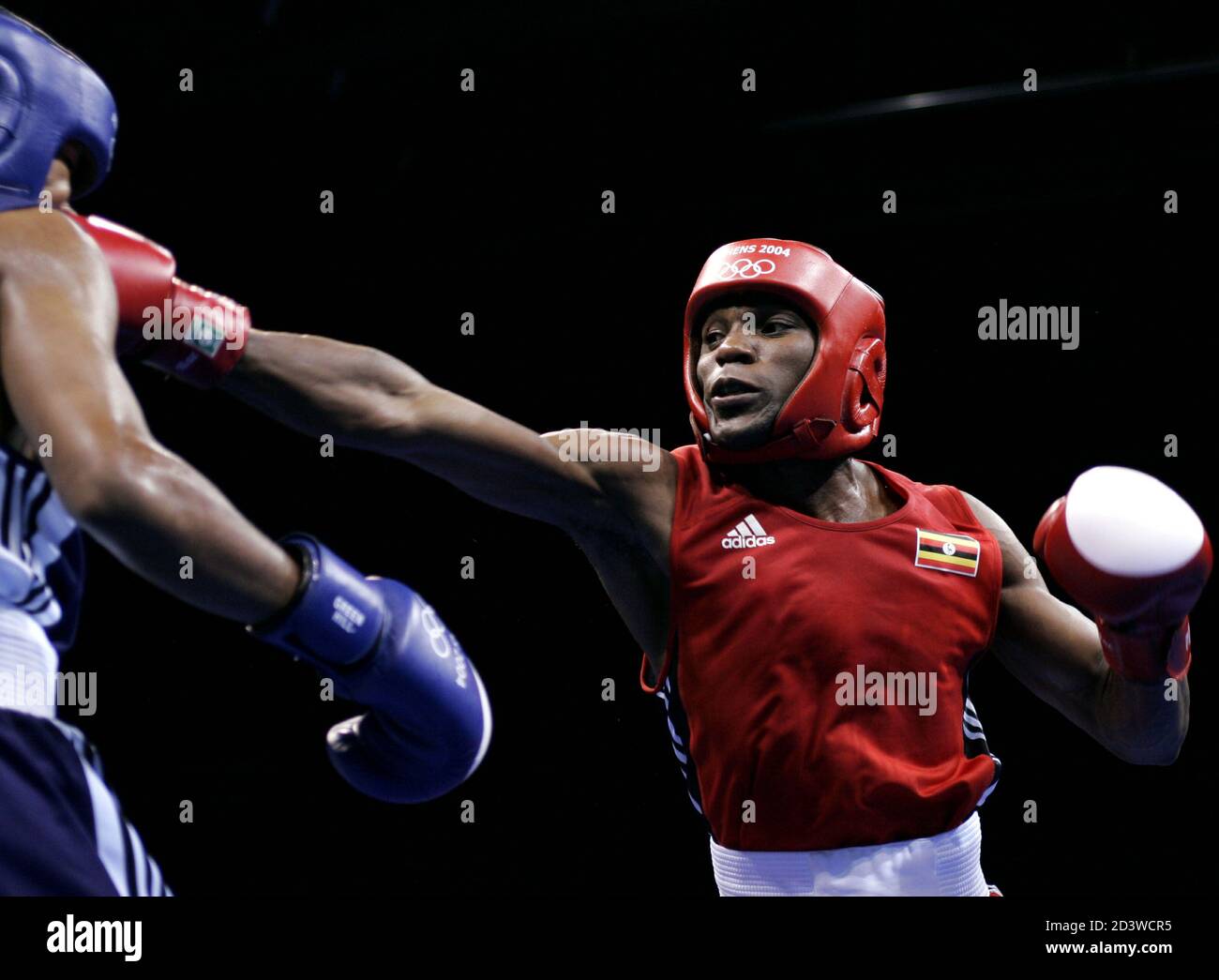 Ugandas Sam Rukundo (R) schlägt Puerto Rico Alexander de Jesus (L) in ihrem Leichtgewicht (60 kg) Runde von 16 Boxkampf bei den Athen 2004 Olympischen Sommerspielen, 20. August 2004. Rukundo gewann den Kampf. Stockfoto