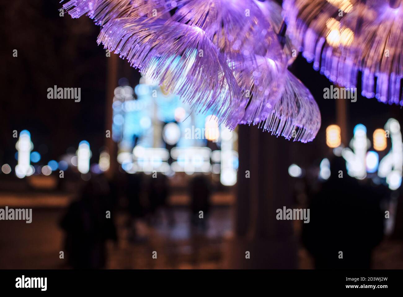 Festliche weihnachtslichter in der Stadt, dekorative Fiberoptik-Lichter auf dunklem Hintergrund Stockfoto