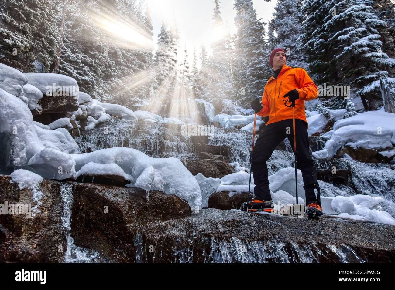 Abenteuermann steht neben einem schönen Wasserfall Stockfoto