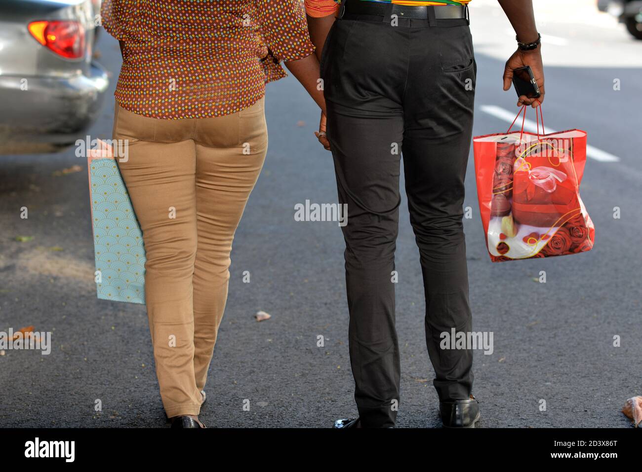 Junge afrikanische Paar in Hosen zu Fuß auf der Straße Stockfoto