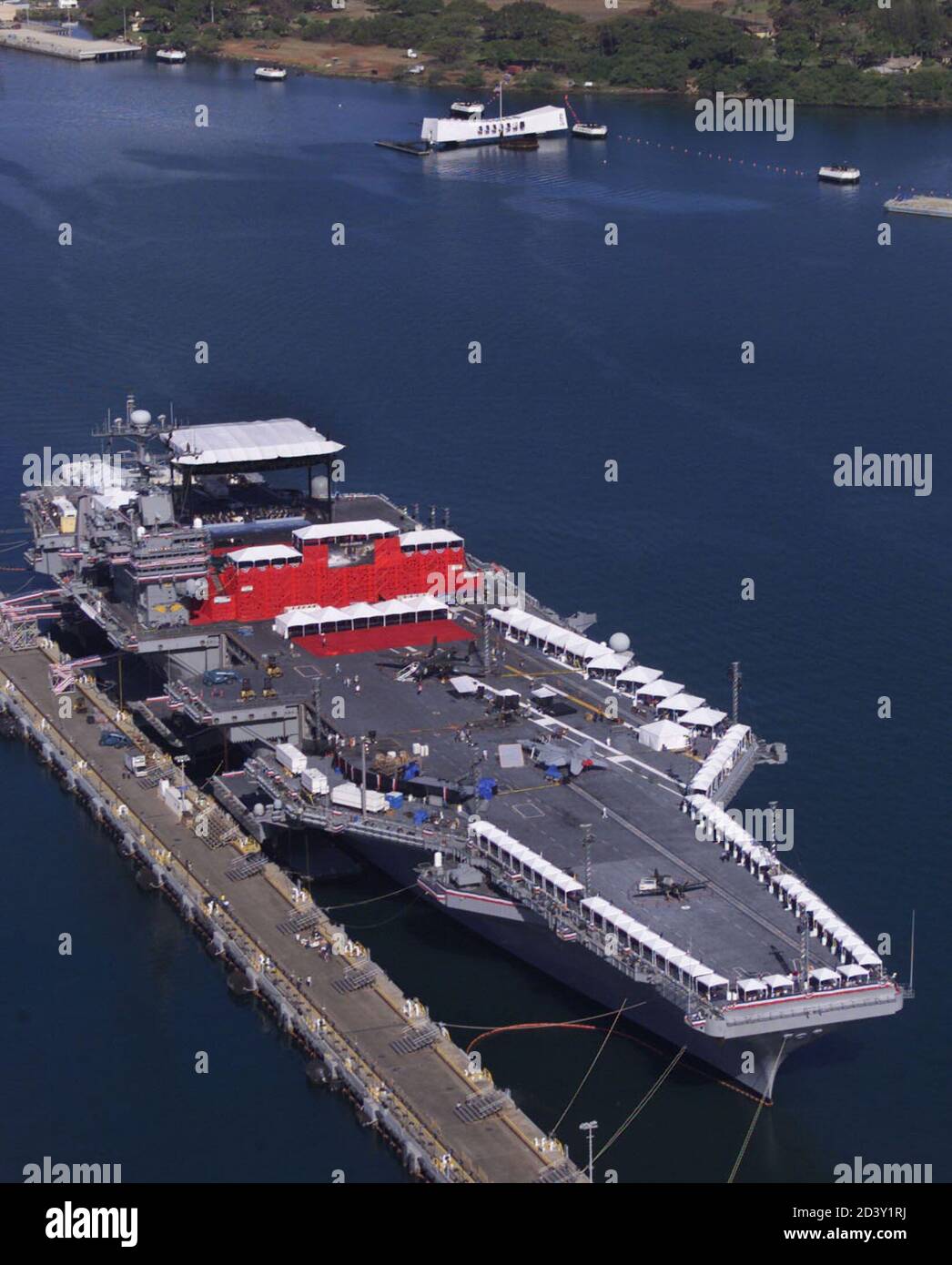 Der Flugzeugträger ist USS John C. Stennis in diesem Luftbild in Honolulu,  Hawaii in Pearl Harbor mit dem Denkmal der USS Arizona im oberen  Hintergrund gezeigt. 21. Mai 2001. Die Walt Disney