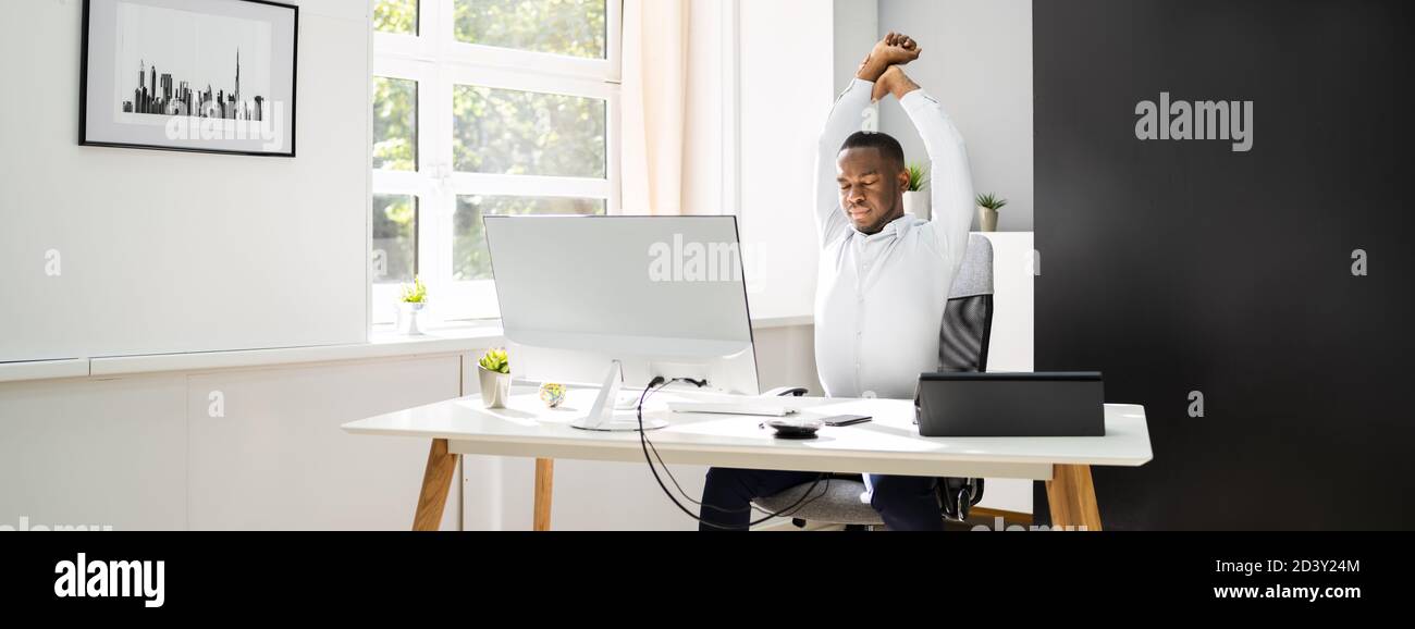 Büro Stretch-Übung Bei Der Arbeit. Afroamerikanischer Mann Stockfoto
