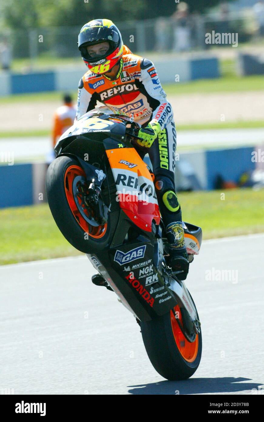 Italiens Valentino Rossi-Radstand seine Honda zur Feier nach dem Gewinn des  britischen MotoGP-Motorcycling Grand Prix in Donington am 12. Juli 2003.  Der Italiener Max Biaggi wurde Zweiter und der Spanier Sete Gibernau